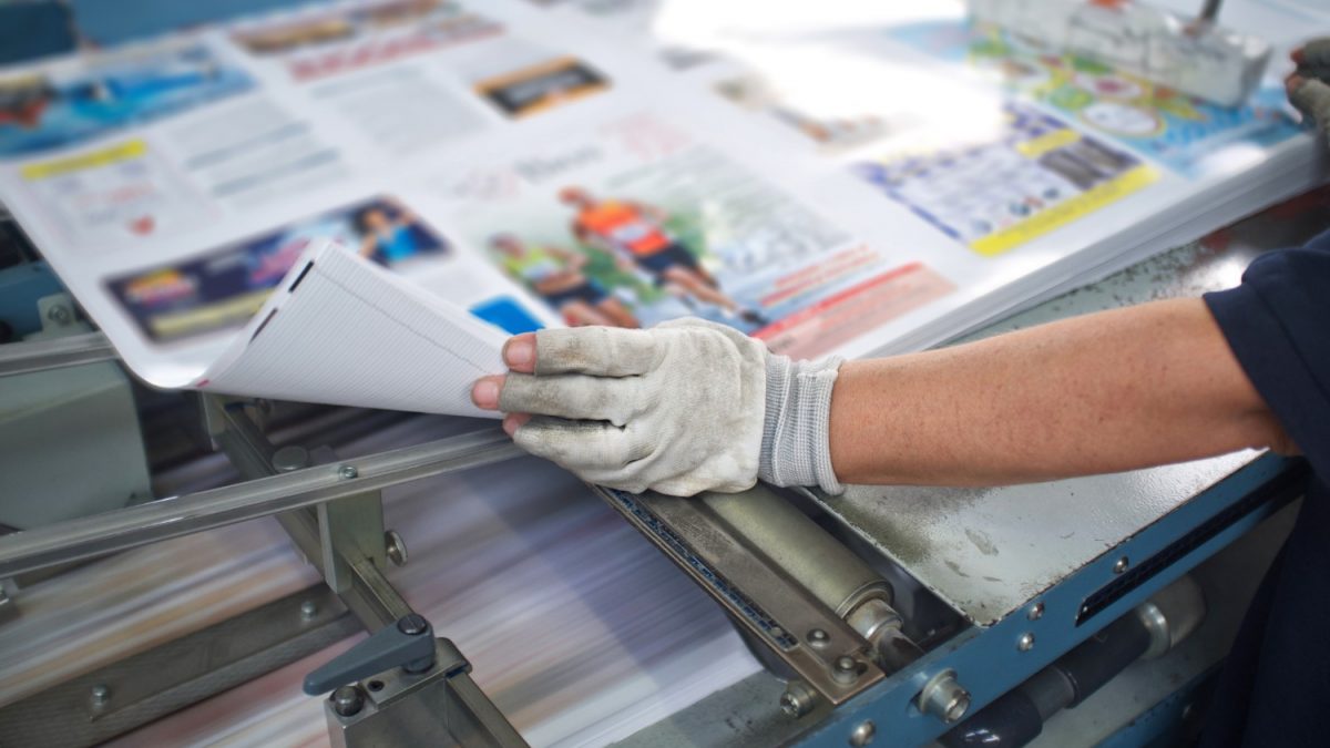 Person wearing a glove, manager a commercial printer